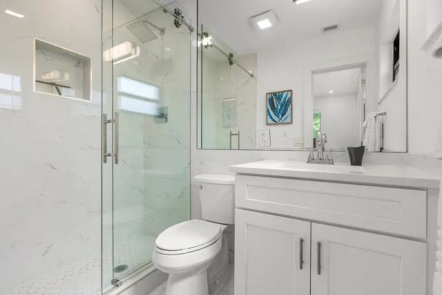 a bathroom with a sink a toilet and shower