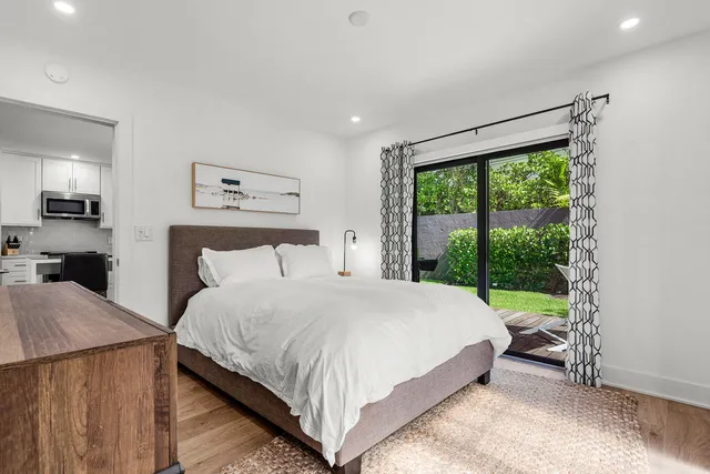 a large bed sitting in a bedroom next to a window