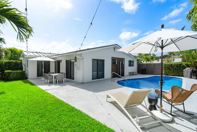 a view of a house with backyard sitting area and furniture