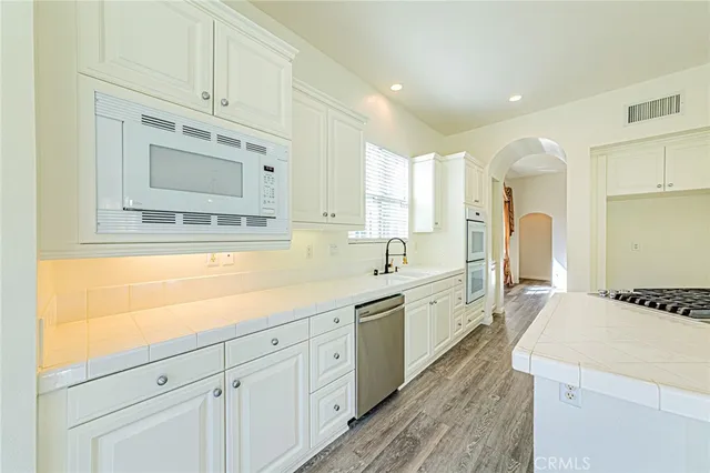 a kitchen with stainless steel appliances granite countertop a sink and a refrigerator