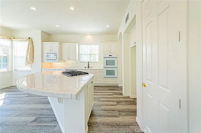 a kitchen with a stove and wooden floor
