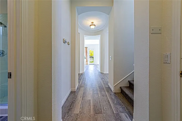 a view of a hallway with wooden floor and windows