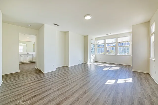 a view of a room that has a window and wooden floor