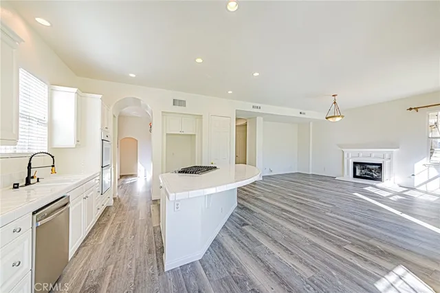a kitchen with stainless steel appliances granite countertop a lot of counter space and wooden floors
