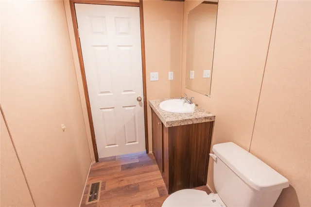 a bathroom with a sink a toilet a mirror and vanity