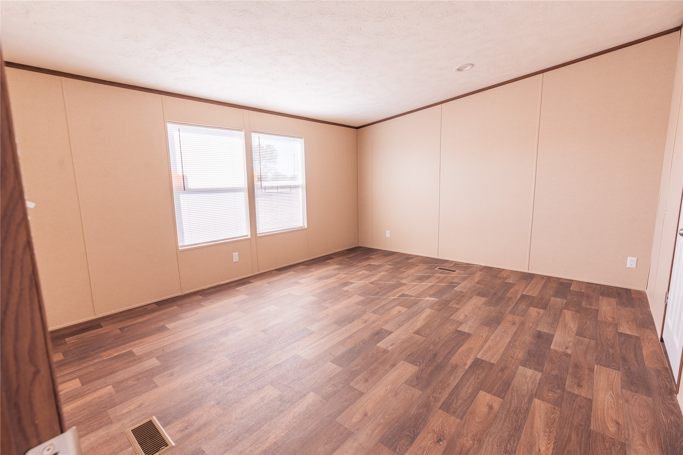 6945 Seawillow Road Lockhart, TX 78644 - Photo 18 of 22 an empty room with wooden floor and windows with curtains