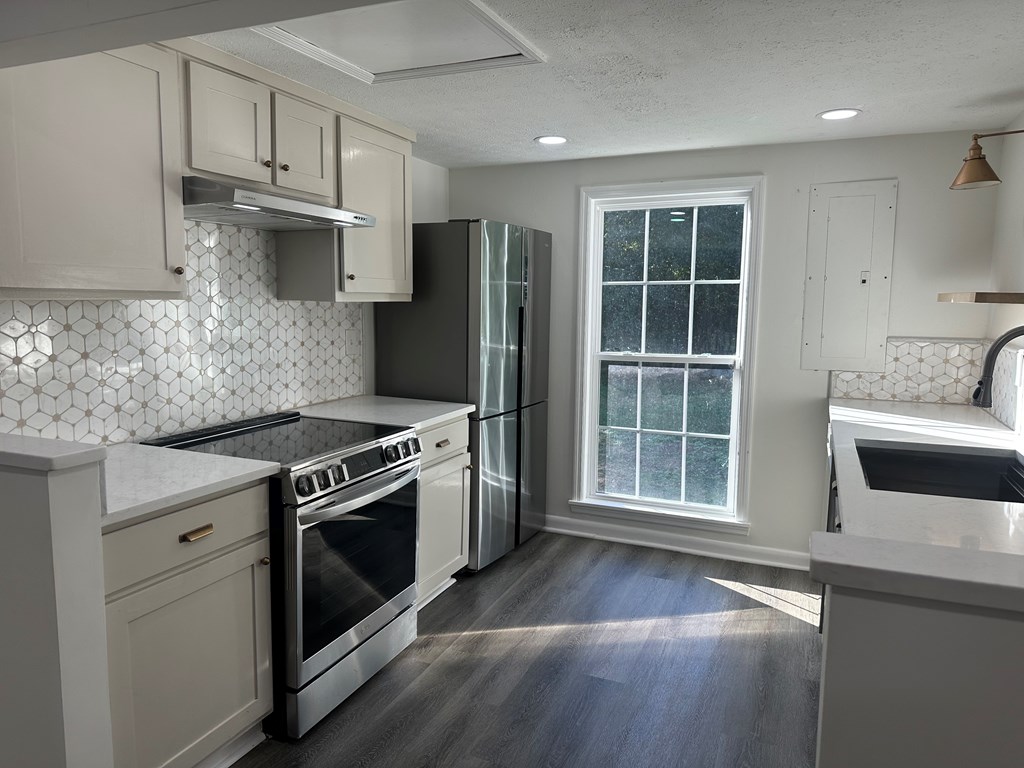 2880 Lamb Road Smiths Station, AL 36877 - Photo 6 of 17 a kitchen with stainless steel appliances granite countertop a stove a sink and a refrigerator