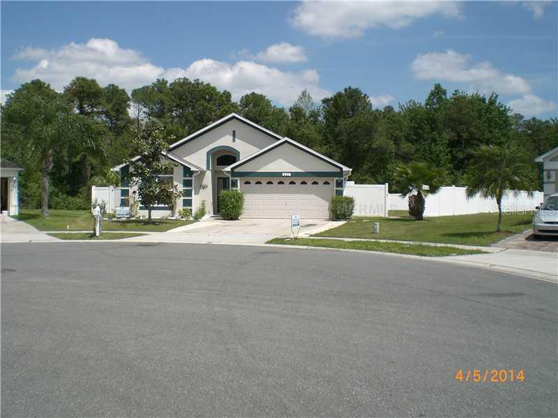 a view of a house with a big yard and large trees