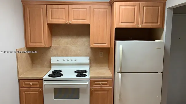a kitchen with a refrigerator sink stove and cabinets