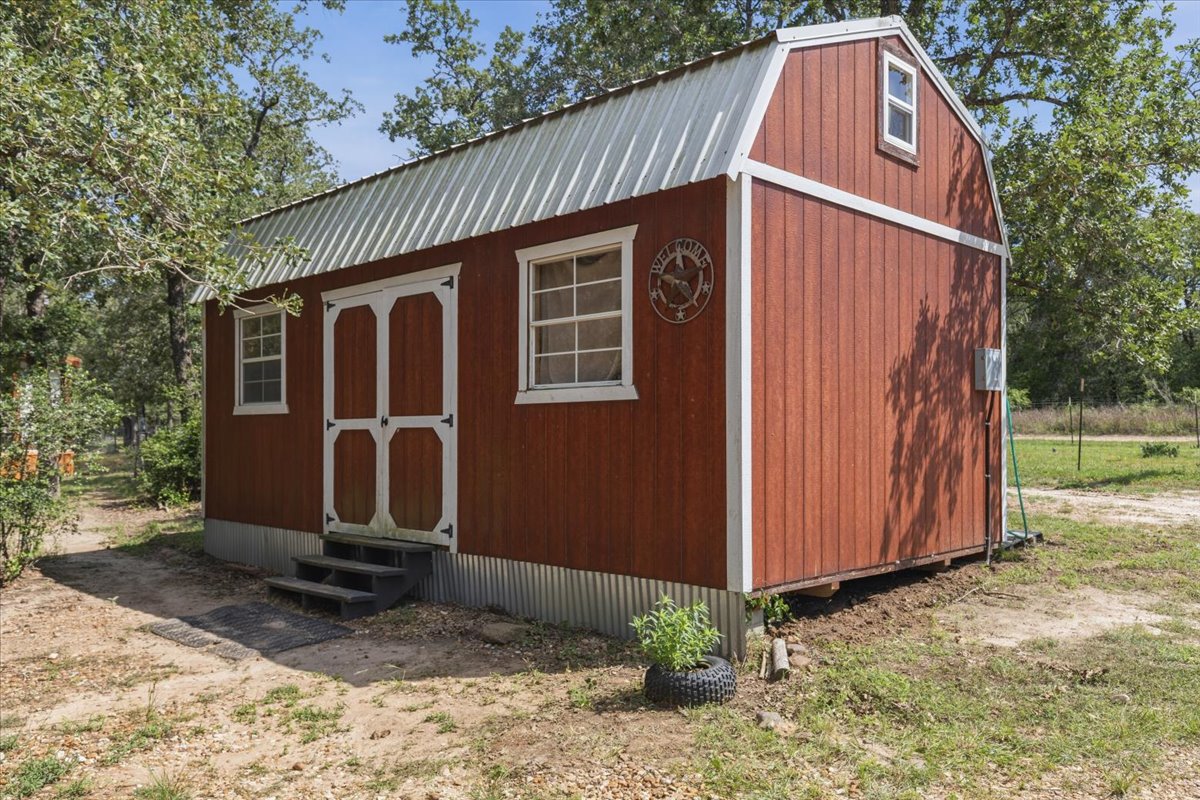 1705 Makinson Road West Point, TX 78963 - Photo 25 of 40 A charming rustic shed with a bright red exterior and white trim offers practical outdoor storage.
