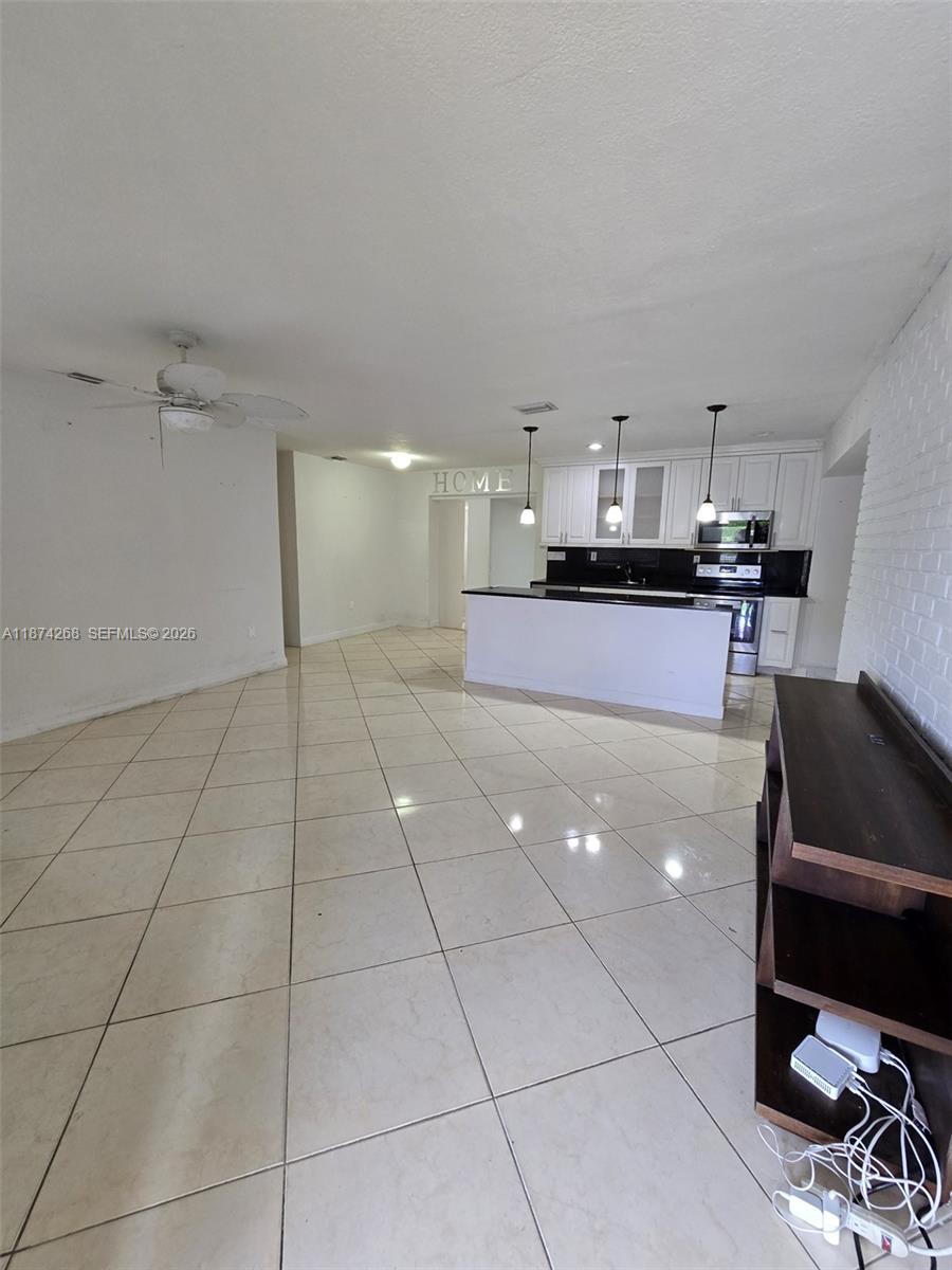 110 West 53rd Street Hialeah, FL 33012 - Photo 8 of 19 a kitchen with kitchen island a counter top space a sink a stove and a window