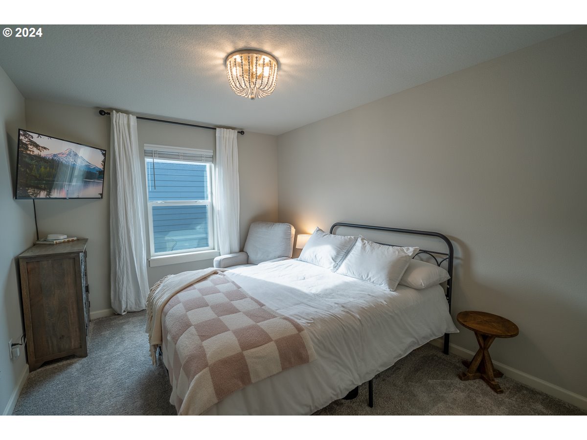 38459 Maple Street Sandy, OR 97055 - Photo 8 of 20 a bedroom with a bed and a chandelier