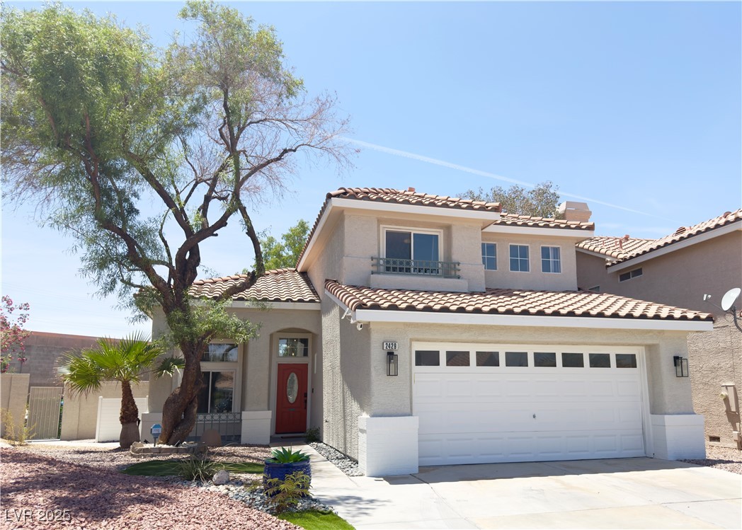 Mediterranean / spanish house featuring a balcony, driveway, and stucco siding