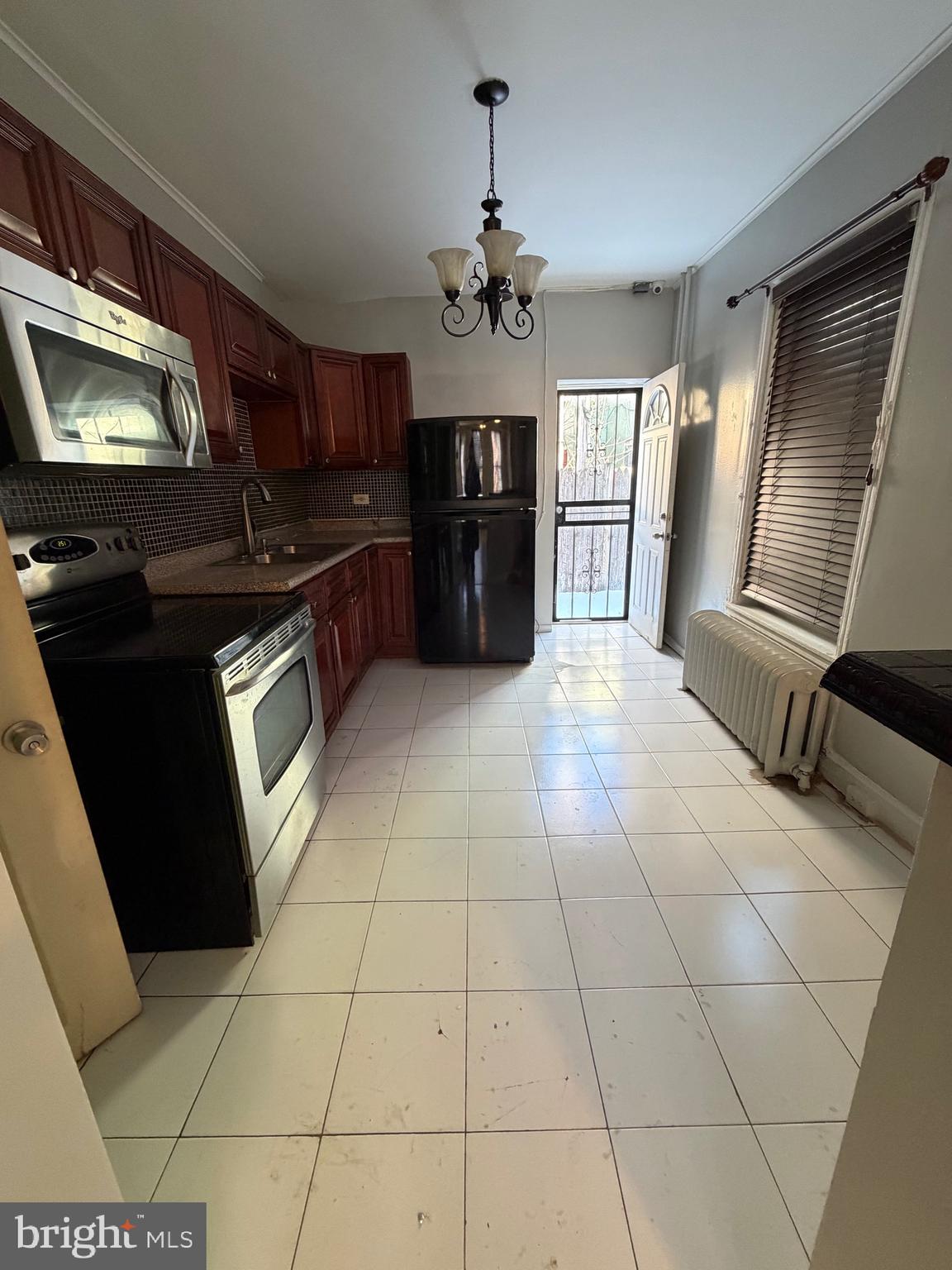 3310 E Street Philadelphia, PA 19134 - Photo 3 of 14 a kitchen with granite countertop a stove a microwave and a counter top space