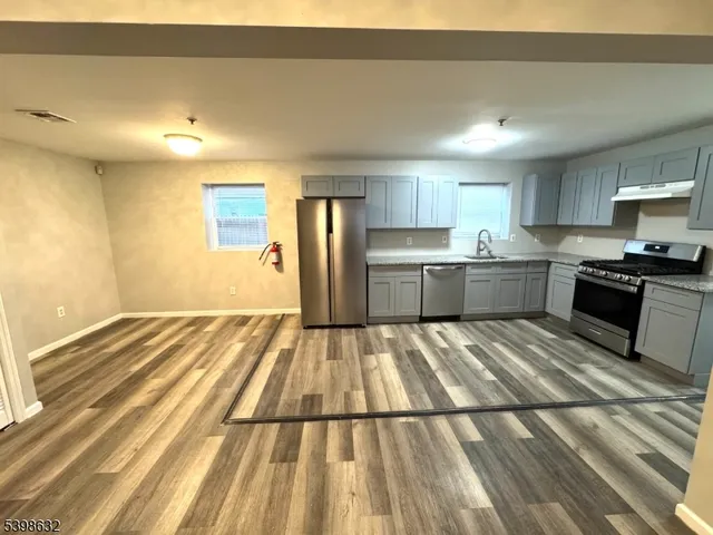 a kitchen with a sink and wooden floor