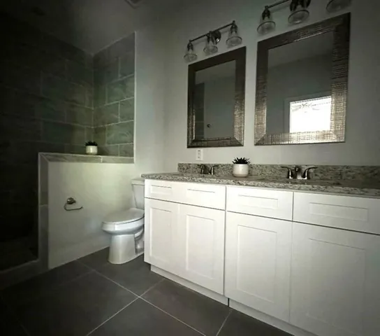 a bathroom with a toilet sink and mirror