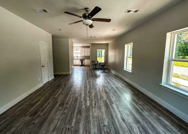 a view of a house with wooden floor and a ceiling fan