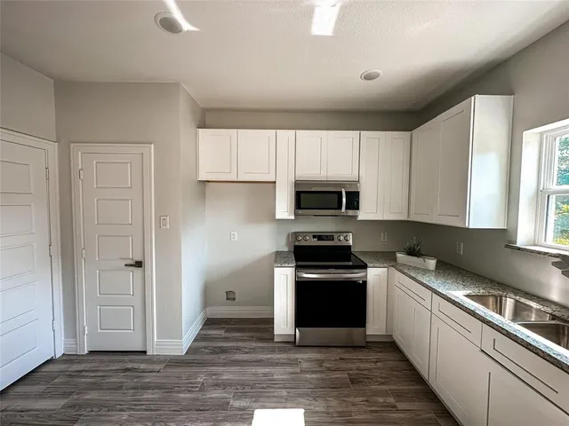 a kitchen with stainless steel appliances granite countertop a stove a sink and a refrigerator