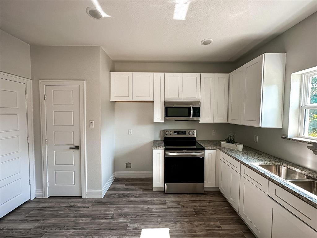 4435 Franklin Street Lancaster, TX 75134 - Photo 4 of 17 a kitchen with stainless steel appliances granite countertop a stove a sink and a refrigerator