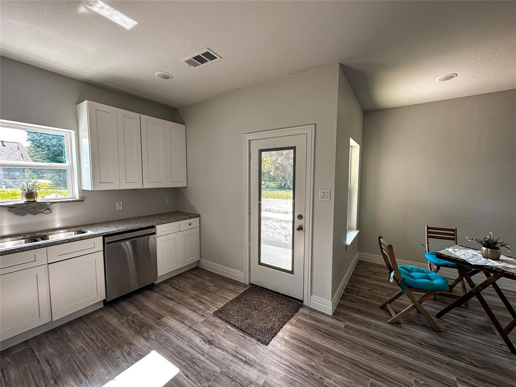 4435 Franklin Street Lancaster, TX 75134 - Photo 5 of 17 a kitchen with granite countertop a stove a sink and white cabinets with wooden floor