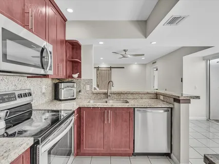 a kitchen with kitchen island granite countertop a stove and a sink