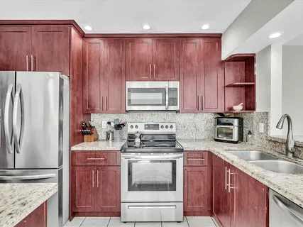 a kitchen with granite countertop wooden cabinets and white appliances