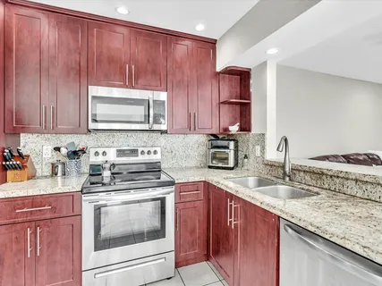 a kitchen with cabinets appliances a sink and a counter top space
