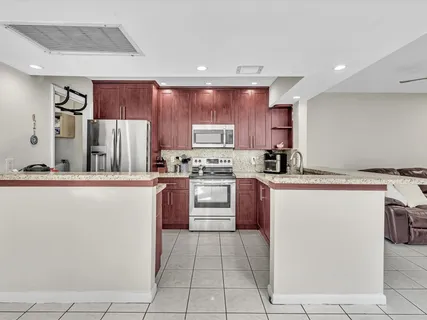 a kitchen with stainless steel appliances granite countertop a refrigerator sink and stove