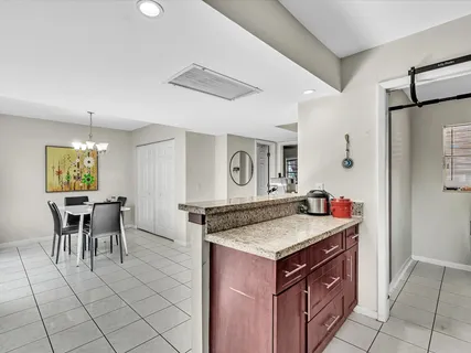 a kitchen with a stove a table and chairs in it