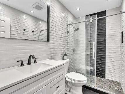 a bathroom with a sink toilet and shower