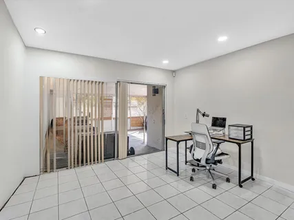 a view of a workspace with furniture and a window