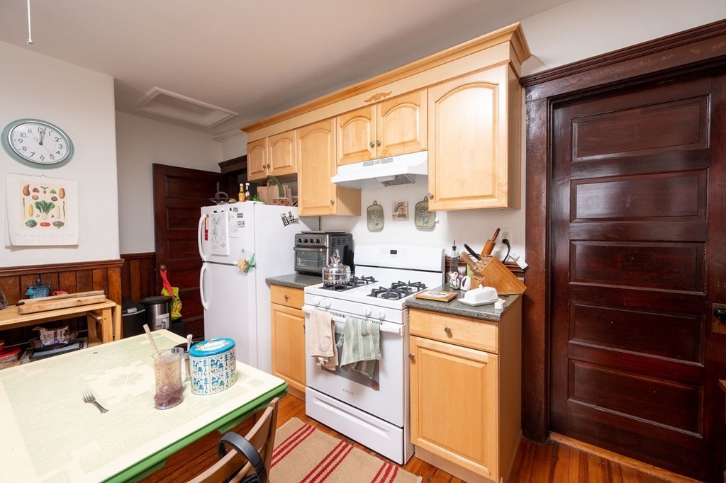 6 Edwin Street Brookline, MA 02445 - Photo 26 of 33 a kitchen with a refrigerator and a stove top open