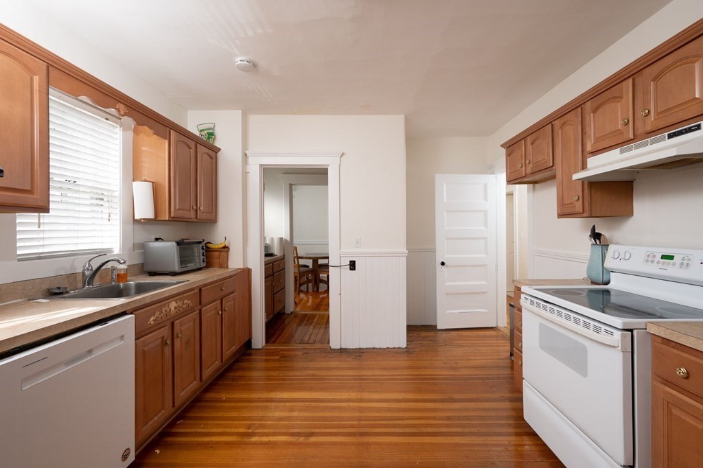 6 Edwin Street Brookline, MA 02445 - Photo 6 of 33 a kitchen with stainless steel appliances granite countertop a sink stove and refrigerator