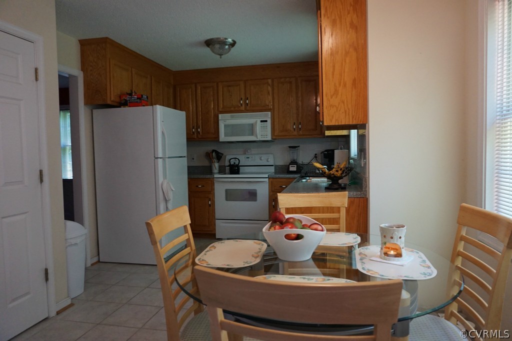 5520 Takach Road Prince George, VA 23875 - Photo 14 of 24 a kitchen with stainless steel appliances granite countertop a refrigerator a sink a stove a dining table and chairs