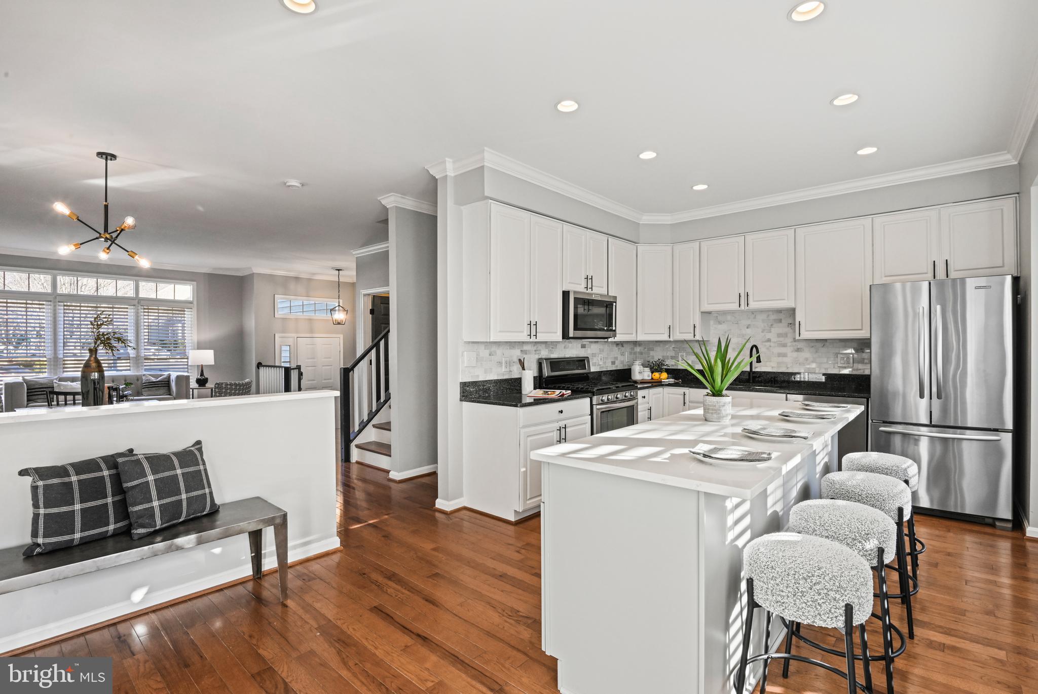 1271 Weatherstone Court Reston, VA 20194 - Photo 12 of 43 a kitchen with a refrigerator a stove cabinets dining table and chairs