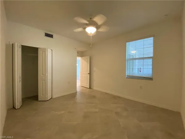 an empty room with windows and closet