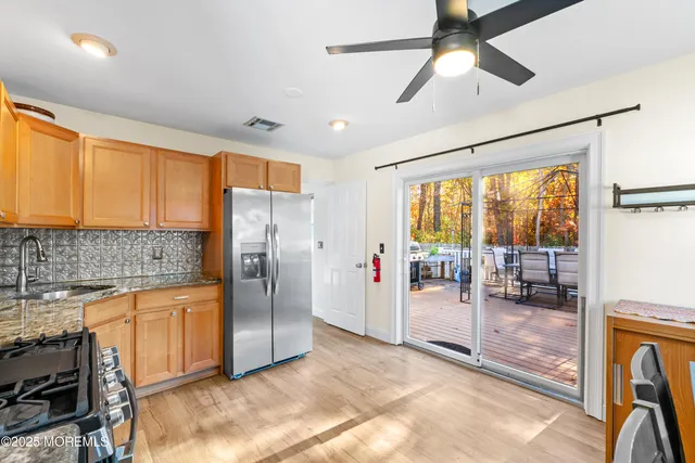 a kitchen with stainless steel appliances granite countertop a refrigerator and a sink