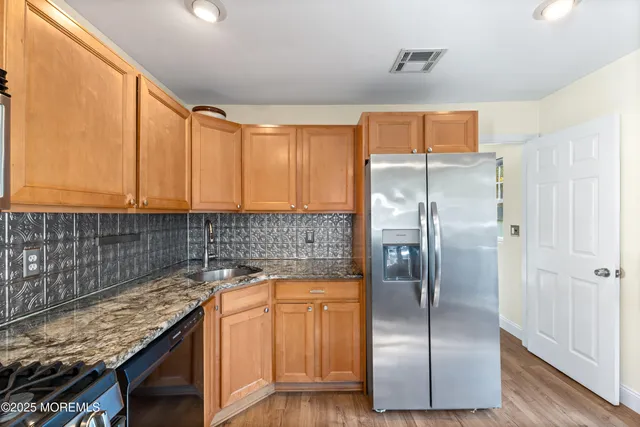 a kitchen with stainless steel appliances granite countertop a refrigerator and a sink