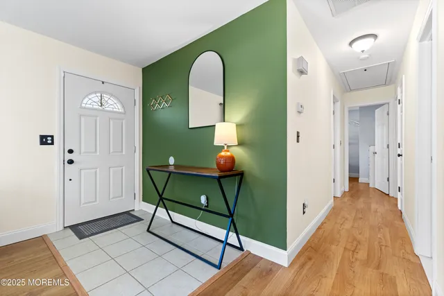 a view of a hallway with entryway wooden floor and front door