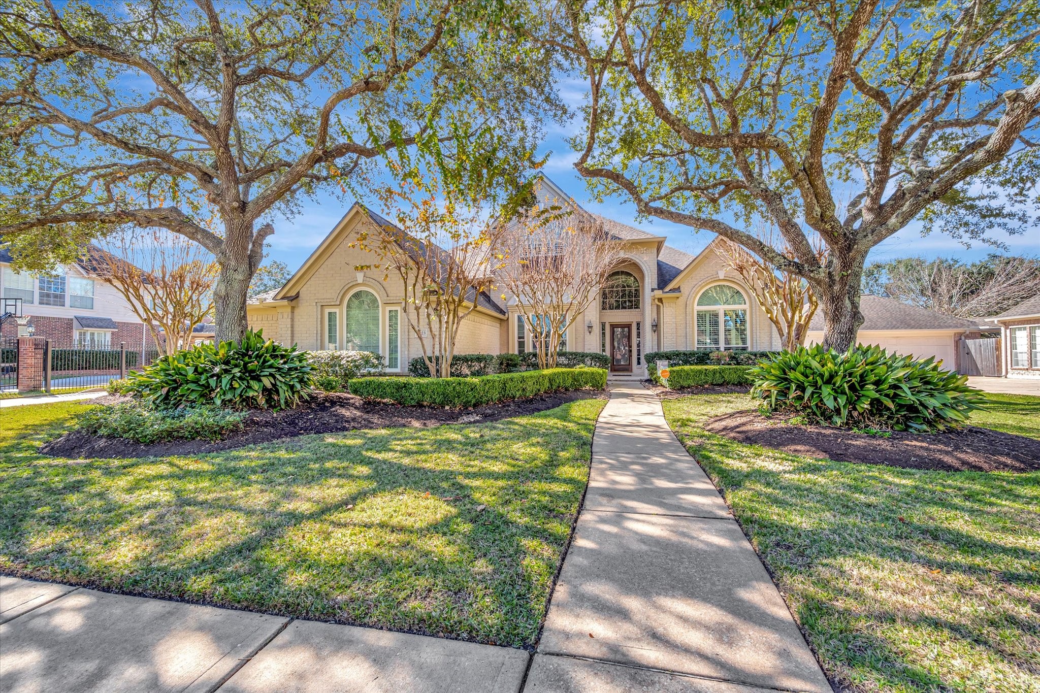 a front view of a house with a garden and trees