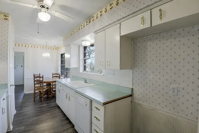 a kitchen with white cabinets and appliances