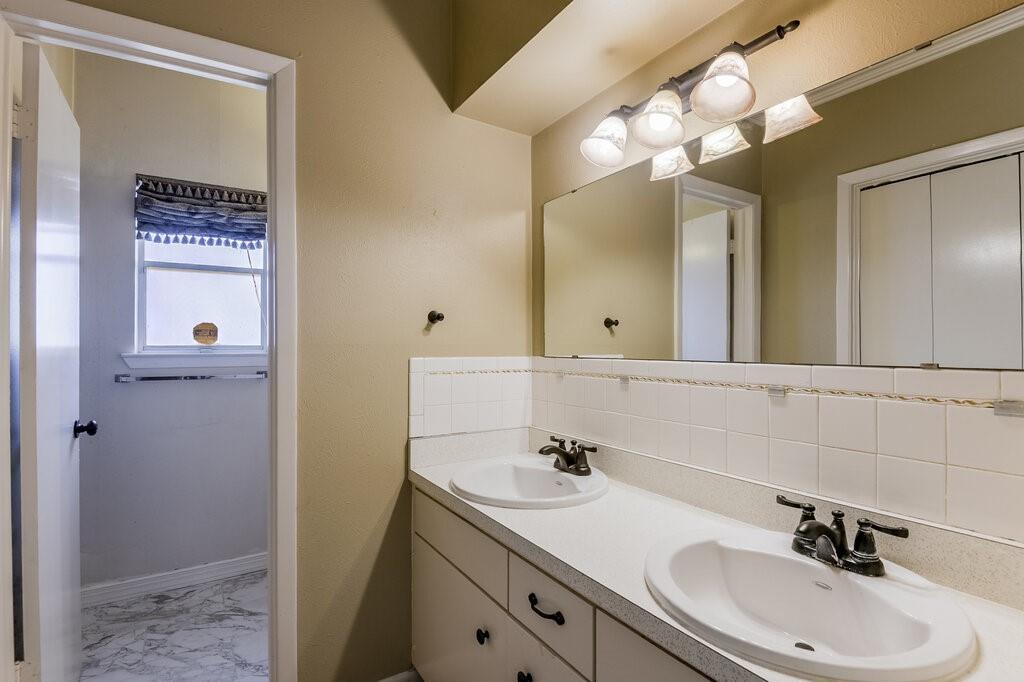 807 North Bowen Road Arlington, TX 76012 - Photo 18 of 25 a bathroom with a sink a light fixture and a mirror