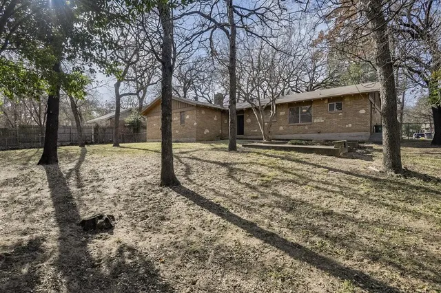 a tree in front of a white house