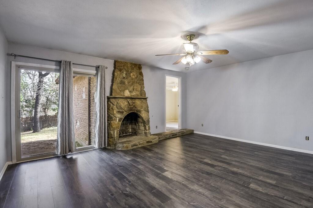 807 North Bowen Road Arlington, TX 76012 - Photo 5 of 25 a view of an empty room with wooden floor fireplace and a window