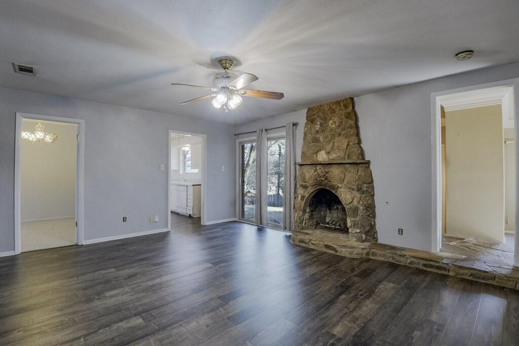807 North Bowen Road Arlington, TX 76012 - Photo 9 of 25 an empty room with fireplace wooden floor and windows