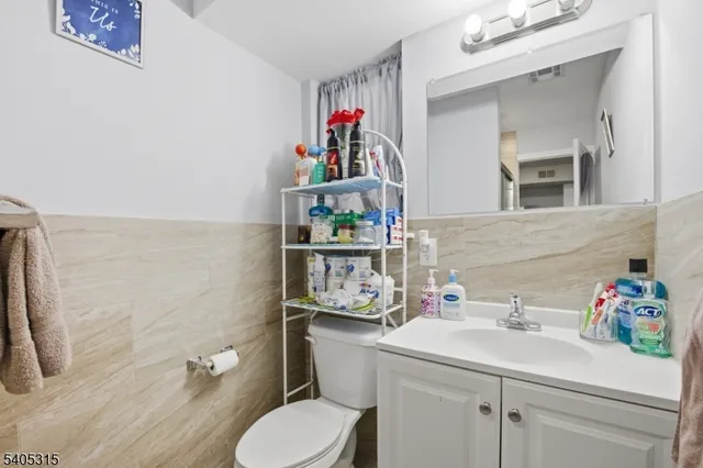 a bathroom with a sink mirror vanity and toilet