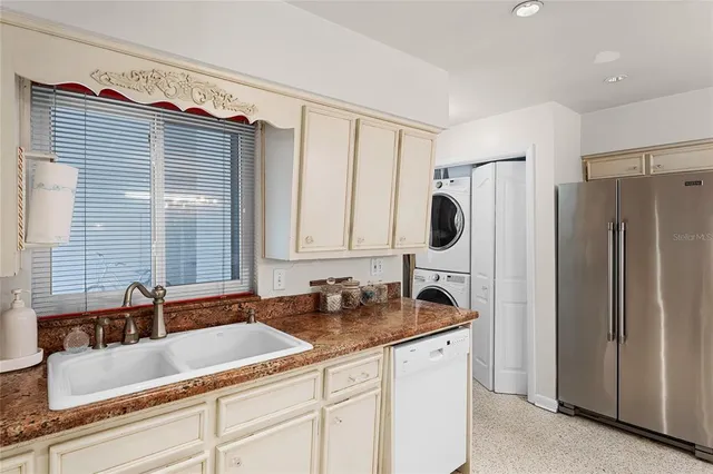 a kitchen with granite countertop a sink and a refrigerator