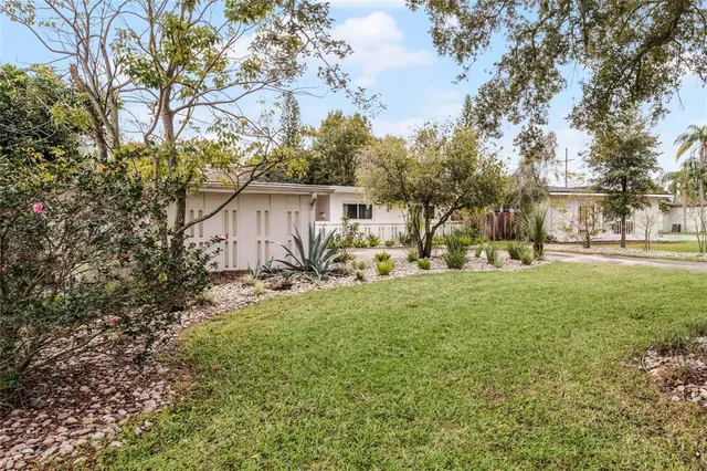 a view of a house with backyard and sitting area