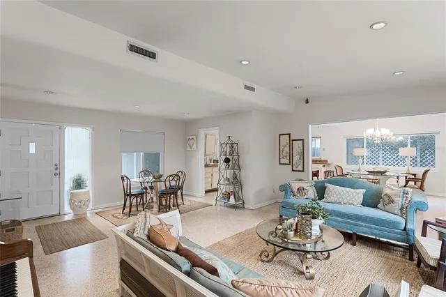 a living room with furniture and a dining table with wooden floor