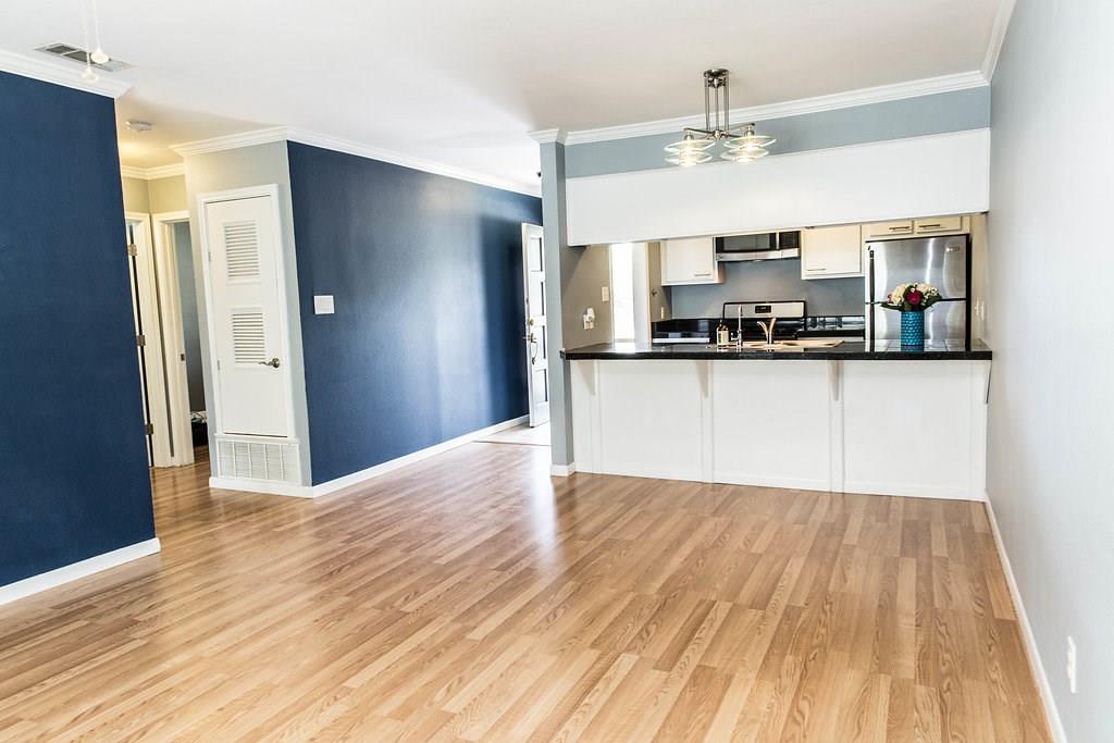 4209 Burnet Road, Unit 206 Austin, TX 78756 - Photo 9 of 20 A well-lit, open-concept living area boasts a modern kitchen and sleek wood flooring.
